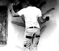 a man is painting a wall with a paint brush